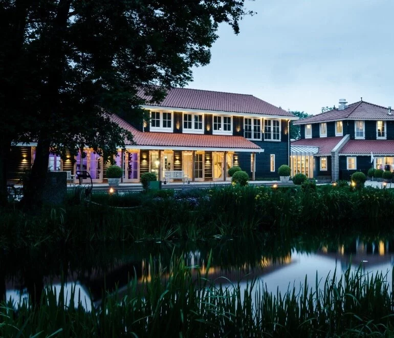 Aanzicht Restaurant 't Ryck vanaf de steiger. Namiddagzon geeft een gele gloed.