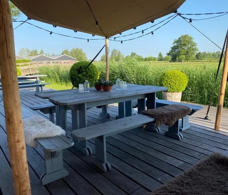 Terras van Bloemryck. Houtentafel met een klein veldboeketje erop.